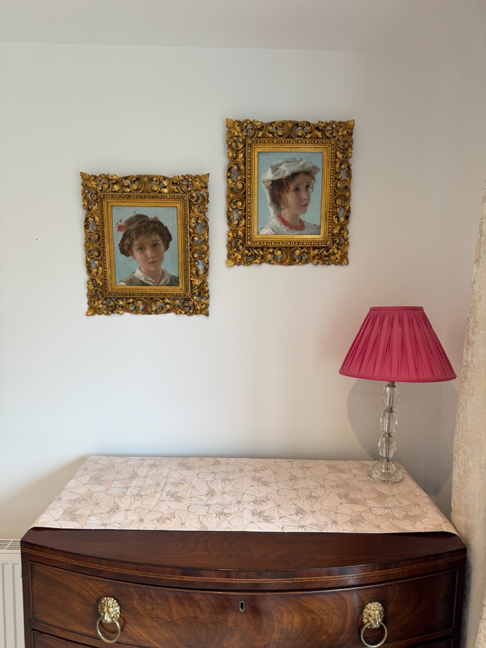 An oil portrait depicting a young child in traditional costume wearing a red coral necklace, presented inside an ornate carved giltwood frame. View III