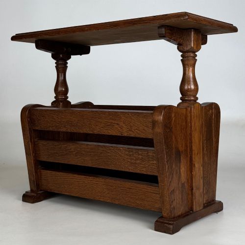fig 1. A medium oak side table featuring a flat rectangular tabletop supported by turned baluster posts above a lower slatted storage trough.