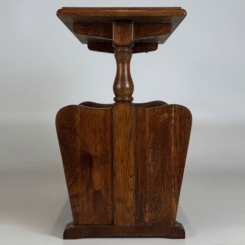fig 2. A medium oak side table featuring a flat rectangular tabletop supported by turned baluster posts above a lower slatted storage trough.