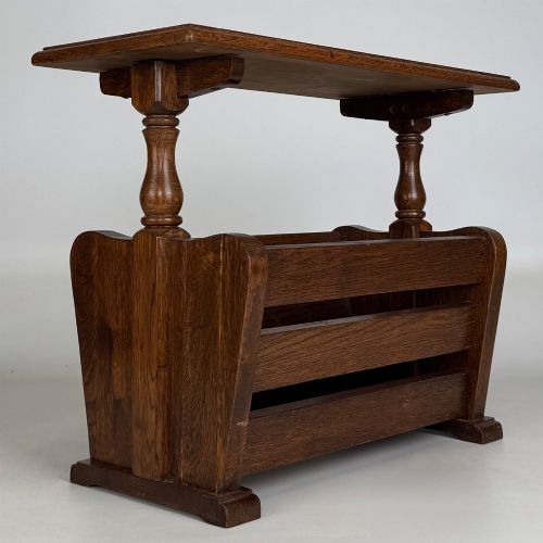fig 3. A medium oak side table featuring a flat rectangular tabletop supported by turned baluster posts above a lower slatted storage trough.