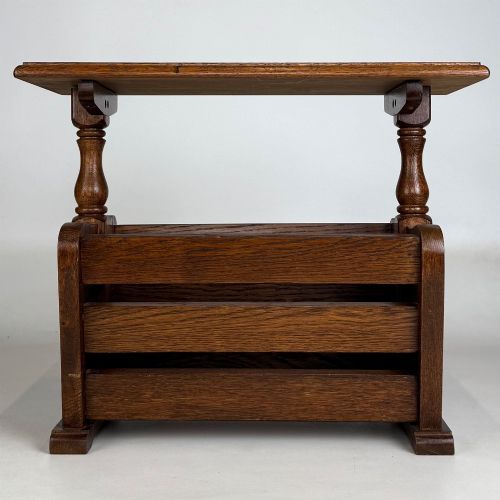 fig 4. A medium oak side table featuring a flat rectangular tabletop supported by turned baluster posts above a lower slatted storage trough.