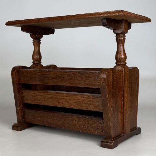 fig 5. A medium oak side table featuring a flat rectangular tabletop supported by turned baluster posts above a lower slatted storage trough.