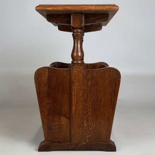 fig 6. A medium oak side table featuring a flat rectangular tabletop supported by turned baluster posts above a lower slatted storage trough.