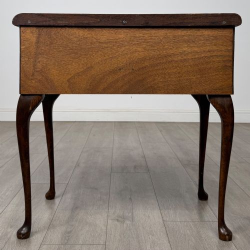 fig 4. An Edwardian oak side table featuring two front drawers with brass drop handles, a scalloped apron, and slender cabriole legs.