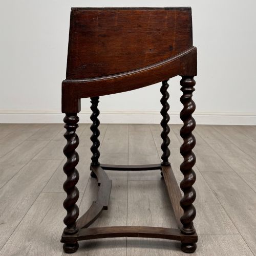 fig 2. A 19th-century dark oak box on a wooden stand featuring four spiral barley twist legs and a central brass keyhole escutcheon.