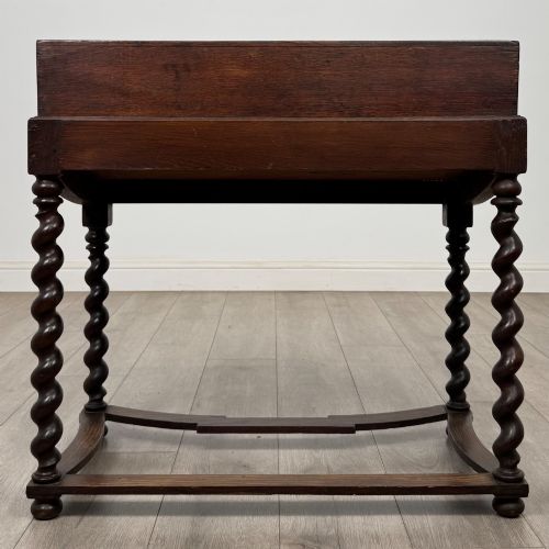 fig 4. A 19th-century dark oak box on a wooden stand featuring four spiral barley twist legs and a central brass keyhole escutcheon.