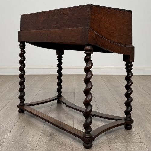 fig 5. A 19th-century dark oak box on a wooden stand featuring four spiral barley twist legs and a central brass keyhole escutcheon.