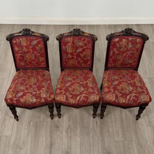 fig 7. A set of six antique 19th-century Victorian oak dining chairs featuring carved crest rails and red patterned fabric upholstery.