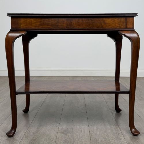 fig 4. An Edwardian burr walnut side table featuring sloped cabriole legs, pad feet, a deep frieze, and a lower undertier shelf.