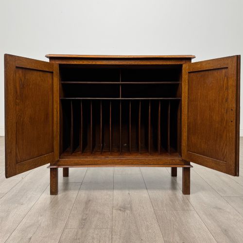 fig 1. An Edwardian warm brown oak fitted cupboard featuring twin recessed panel doors, a central wooden latch, and four straight legs.