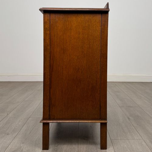 fig 3. An Edwardian warm brown oak fitted cupboard featuring twin recessed panel doors, a central wooden latch, and four straight legs.