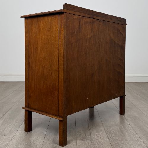 fig 4. An Edwardian warm brown oak fitted cupboard featuring twin recessed panel doors, a central wooden latch, and four straight legs.