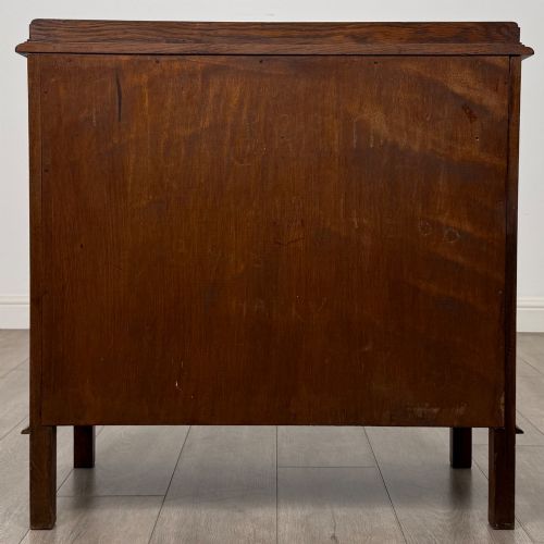 fig 5. An Edwardian warm brown oak fitted cupboard featuring twin recessed panel doors, a central wooden latch, and four straight legs.