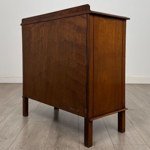 fig 6. An Edwardian warm brown oak fitted cupboard featuring twin recessed panel doors, a central wooden latch, and four straight legs.
