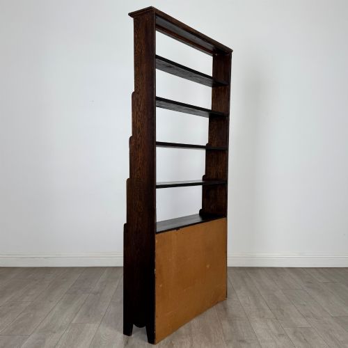 fig 5. A tall dark oak open bookcase featuring multiple upper shelves and a two-door lower cupboard base.