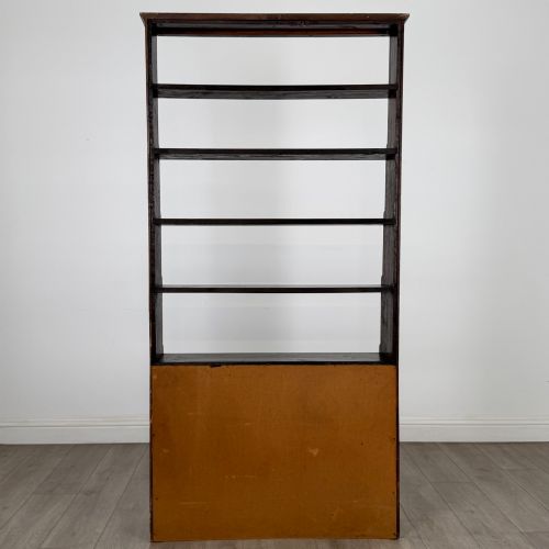 fig 6. A tall dark oak open bookcase featuring multiple upper shelves and a two-door lower cupboard base.