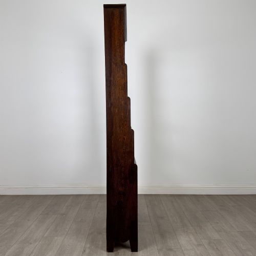 fig 8. A tall dark oak open bookcase featuring multiple upper shelves and a two-door lower cupboard base.