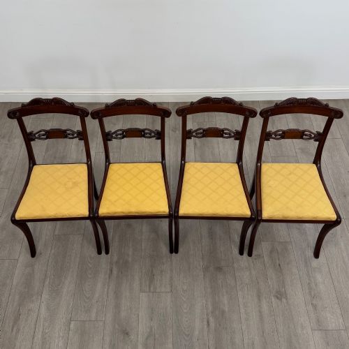 fig 1. A set of ten mahogany Regency style dining chairs with yellow upholstered seats, including eight side chairs and two carvers with scrolling arms.