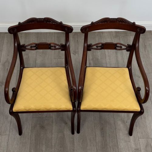 fig 3. A set of ten mahogany Regency style dining chairs with yellow upholstered seats, including eight side chairs and two carvers with scrolling arms.