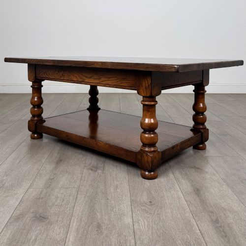 fig 1. A rectangular dark oak coffee table featuring turned baluster legs and a full-length lower shelf.