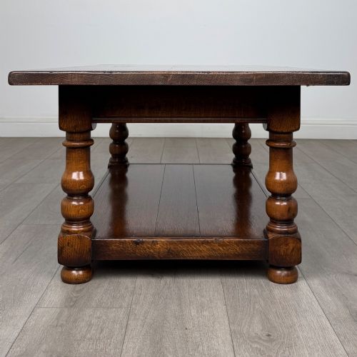 fig 2. A rectangular dark oak coffee table featuring turned baluster legs and a full-length lower shelf.
