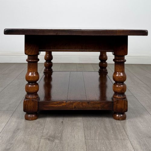 fig 6. A rectangular dark oak coffee table featuring turned baluster legs and a full-length lower shelf.