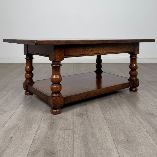 fig 7. A rectangular dark oak coffee table featuring turned baluster legs and a full-length lower shelf.