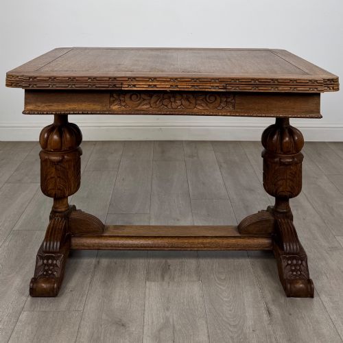 fig 3. An antique Edwardian oak draw-leaf dining table featuring carved bulbous supports and a central stretcher.