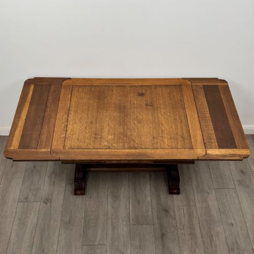 fig 4. An antique Edwardian oak draw-leaf dining table featuring carved bulbous supports and a central stretcher.