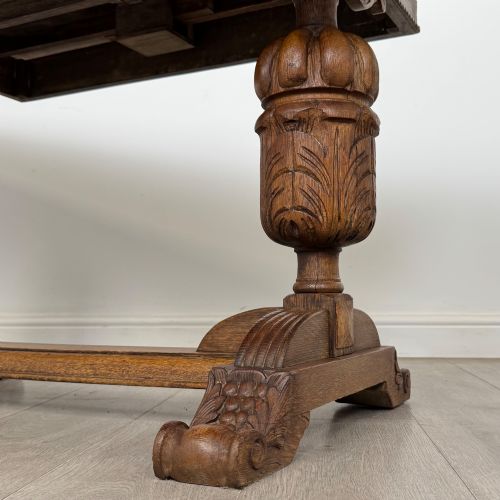 fig 6. An antique Edwardian oak draw-leaf dining table featuring carved bulbous supports and a central stretcher.
