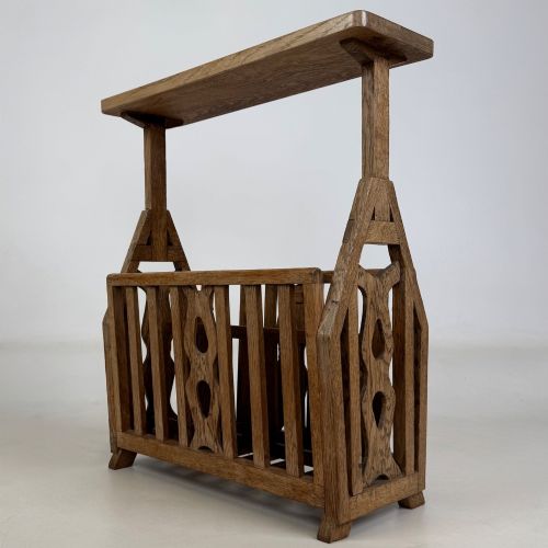 fig 1. An antique Arts and Crafts oak side table featuring a rectangular top supported by slender uprights above a slatted lower magazine trough.