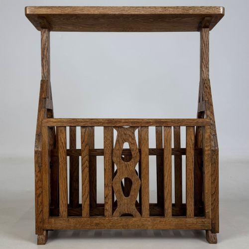 fig 4. An antique Arts and Crafts oak side table featuring a rectangular top supported by slender uprights above a slatted lower magazine trough.
