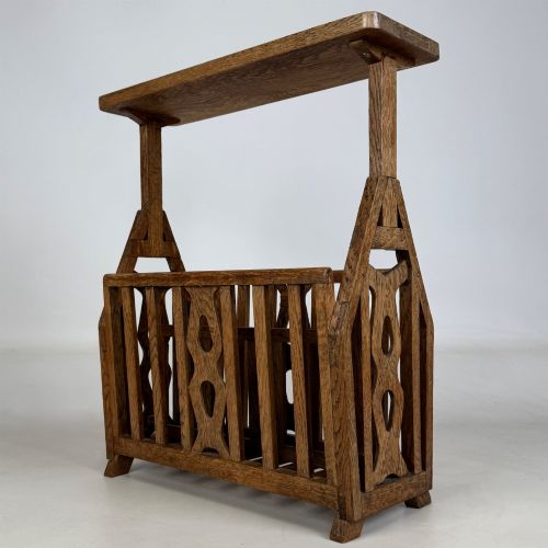 fig 5. An antique Arts and Crafts oak side table featuring a rectangular top supported by slender uprights above a slatted lower magazine trough.