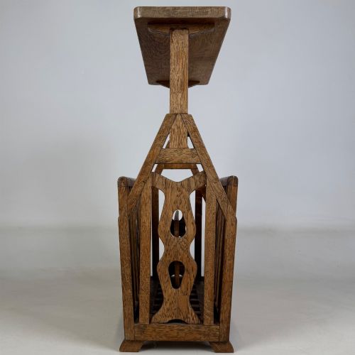 fig 6. An antique Arts and Crafts oak side table featuring a rectangular top supported by slender uprights above a slatted lower magazine trough.