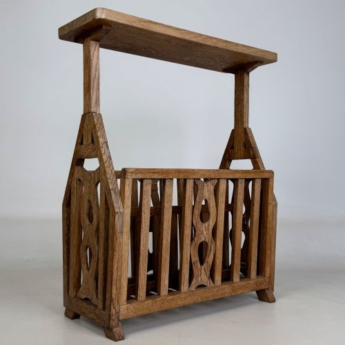 fig 7. An antique Arts and Crafts oak side table featuring a rectangular top supported by slender uprights above a slatted lower magazine trough.