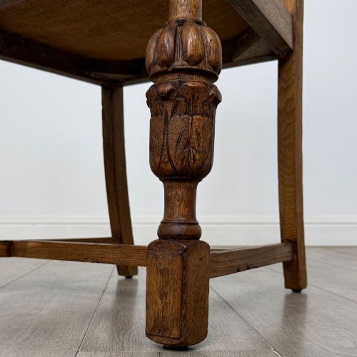 fig 5. A set of four Edwardian oak dining chairs featuring carved back splats, brown upholstered seats, and bulbous turned front legs.