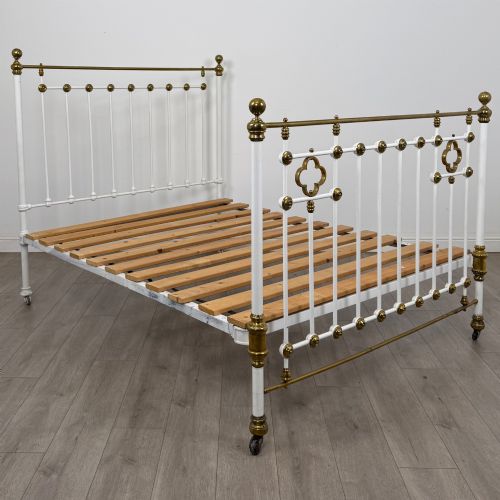 fig 1. Victorian white-painted iron and polished brass king-size bedstead featuring round brass finials and quatrefoil metalwork.