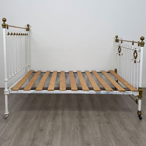 fig 2. Victorian white-painted iron and polished brass king-size bedstead featuring round brass finials and quatrefoil metalwork.