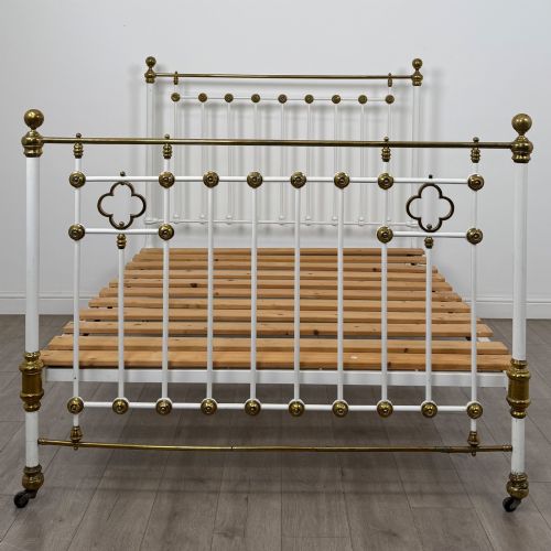 fig 3. Victorian white-painted iron and polished brass king-size bedstead featuring round brass finials and quatrefoil metalwork.