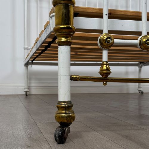 fig 6. Victorian white-painted iron and polished brass king-size bedstead featuring round brass finials and quatrefoil metalwork.