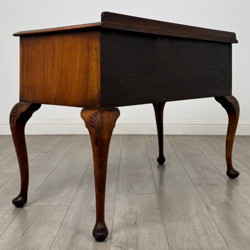 fig 3. An Edwardian burr walnut writing table featuring five drawers with brass drop handles and carved cabriole legs.