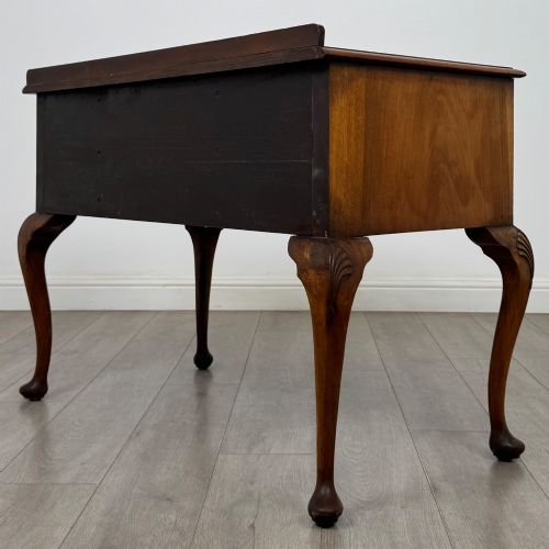 fig 5. An Edwardian burr walnut writing table featuring five drawers with brass drop handles and carved cabriole legs.