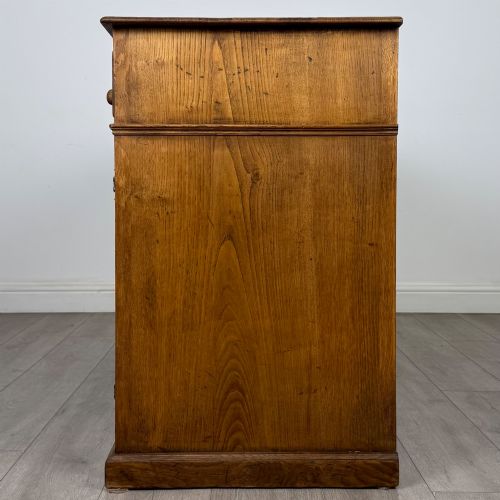 fig 3. An antique golden oak dresser base featuring three top drawers, two panelled outer doors, and a central arched open recess.