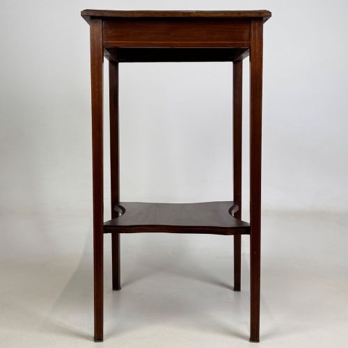 fig 2. A tall Edwardian mahogany side table featuring four slender tapered legs, a square top surface, and a concave-shaped lower undertier.