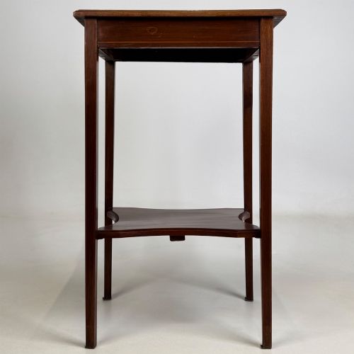fig 4. A tall Edwardian mahogany side table featuring four slender tapered legs, a square top surface, and a concave-shaped lower undertier.