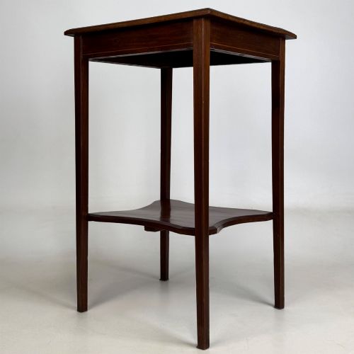 fig 5. A tall Edwardian mahogany side table featuring four slender tapered legs, a square top surface, and a concave-shaped lower undertier.