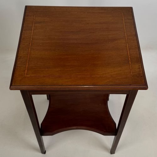 fig 8. A tall Edwardian mahogany side table featuring four slender tapered legs, a square top surface, and a concave-shaped lower undertier.