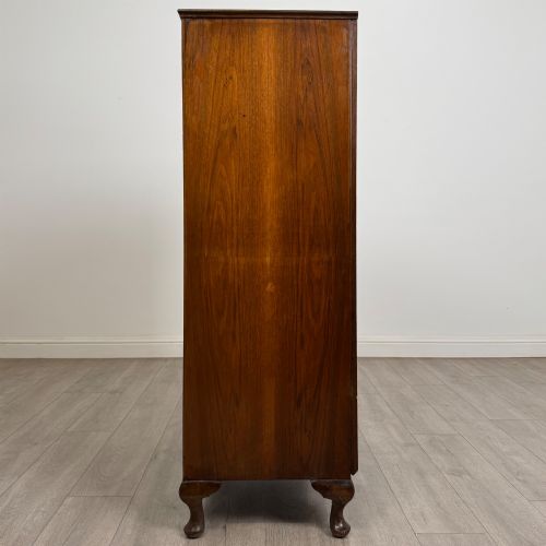 fig 3. An Edwardian burr walnut storage cupboard featuring two top doors with brass strap hinges above two drawers on cabriole legs.