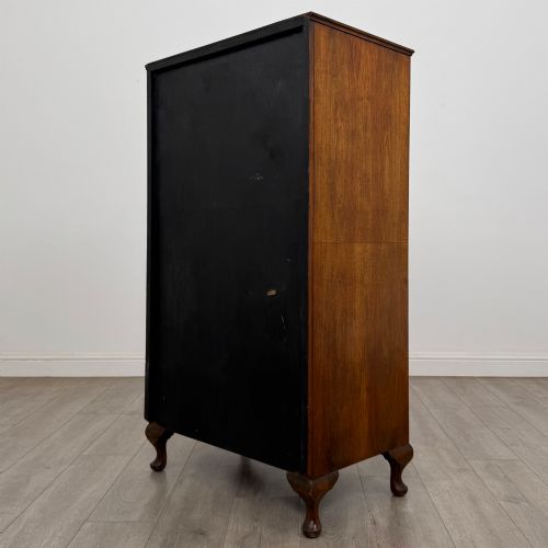 fig 6. An Edwardian burr walnut storage cupboard featuring two top doors with brass strap hinges above two drawers on cabriole legs.
