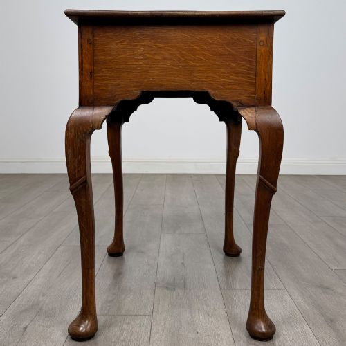fig 2. An 18th-century Georgian oak side table featuring a single drawer with geometric inlaid border, lion mask brass ring handles, shaped apron, and four cabriole legs ending in pad feet.